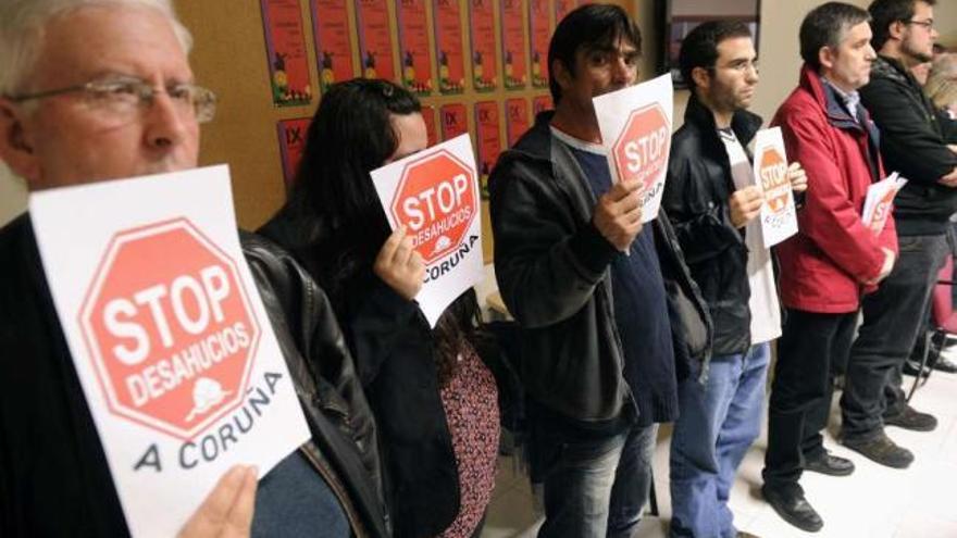 Miembros de la plataforma Stop Desahucios y uno de los afectados, durante el pleno de ayer. / juan varela