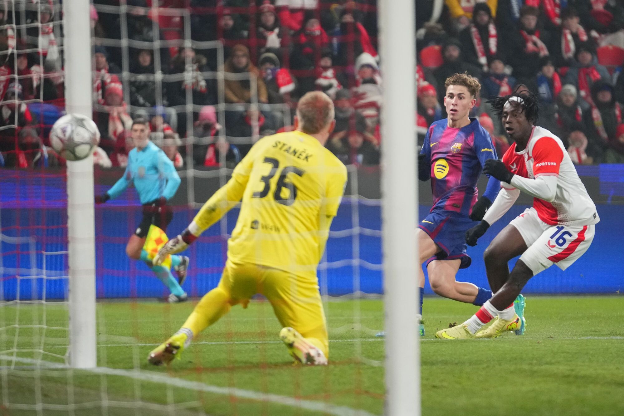 Barcelona's Fermin Lopez, center, scores his side's opening goal past Slavia's David Moses, right, and Slavia's goalkeeper Jindrich Stanek during the Champions League opening phase soccer match between Slavia Prague and Barcelona in Prague, Czech Republic, Wednesday, Jan. 21, 2026. (AP Photo/Petr David Josek)