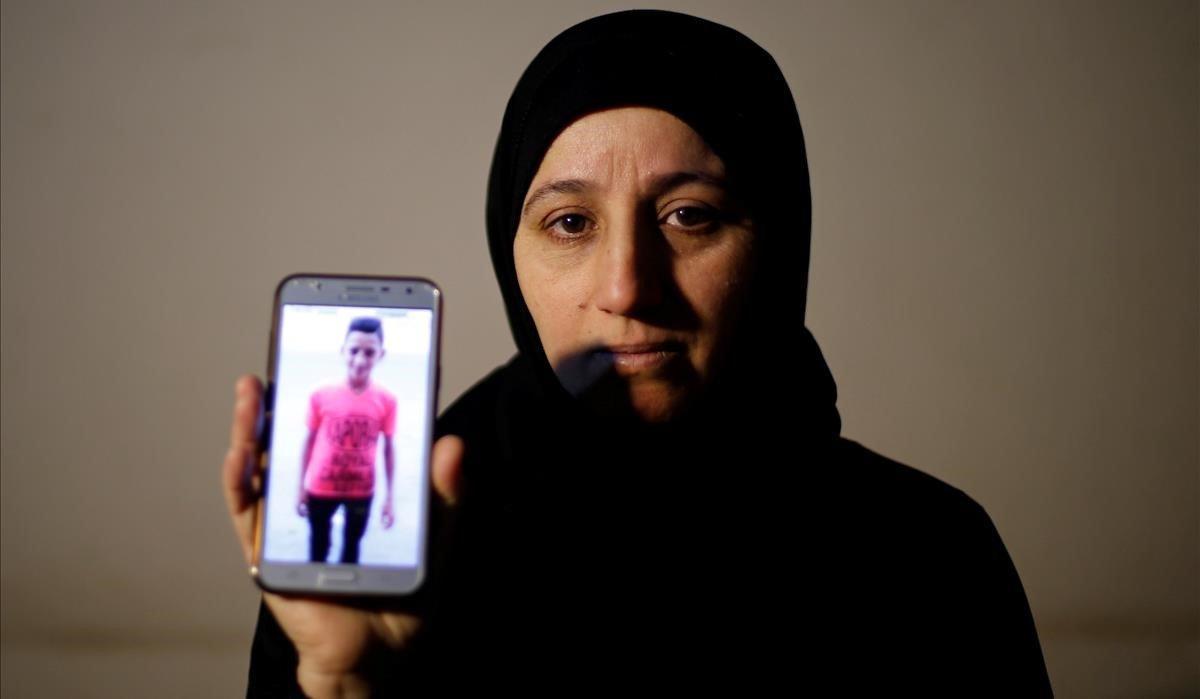 La madre del adolescente palestino Mohammad Ayoub, quien fue asesinado durante una protesta en la cerca de la frontera entre Israel y Gaza, muestra su foto en un teléfono móvil en su casa en Gaza.