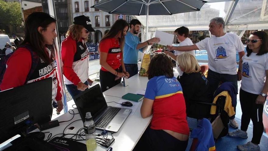 Algunos competidores recogen el dorsal de la competición, ayer en la plaza de España.