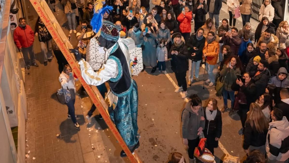 Un patge reial puja els regals amb les escales durant la Cavalcada de l'any passat