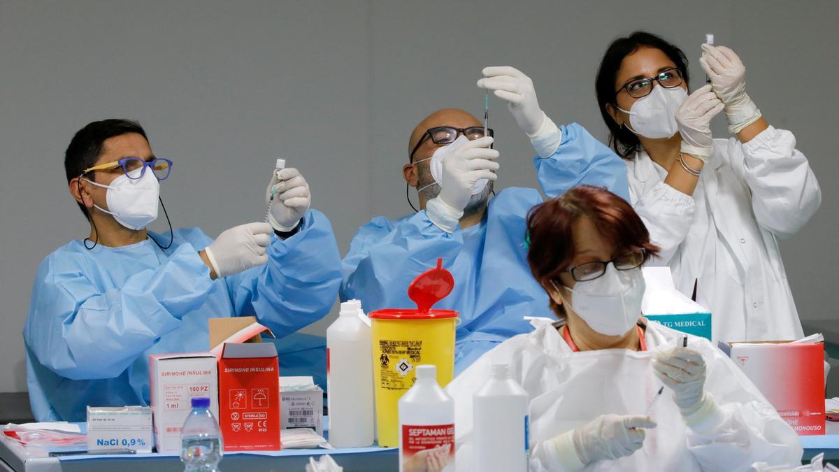 Tres sanitarios preparan inyecciones con vacunas en Nápoles.