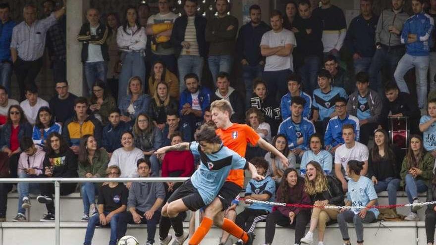 Varios jóvenes contemplan un partido de fútbol en el campo de A Bandeira. // Bernabé/Ana Agra