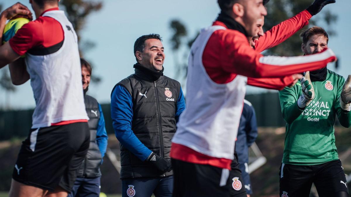 Míchel Sánchez somriu enmig dels jugadors, en l’entrenament d’ahir a La Vinya