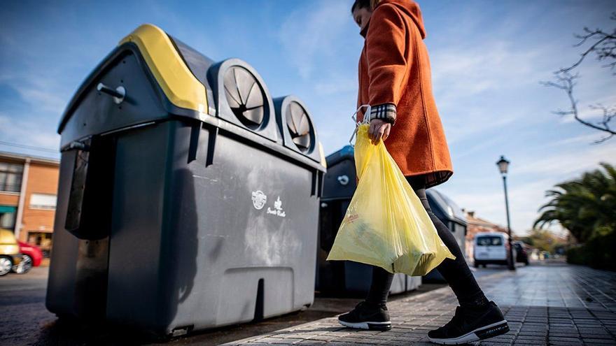 Una persona recicla en el contenedor amarillo