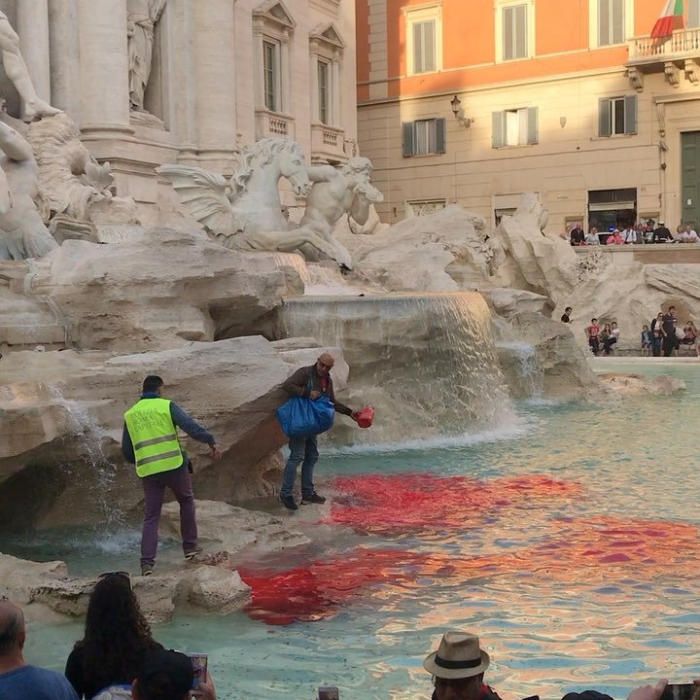 Un hombre vertiendo tinte en la Fontana di Trevi en Roma.