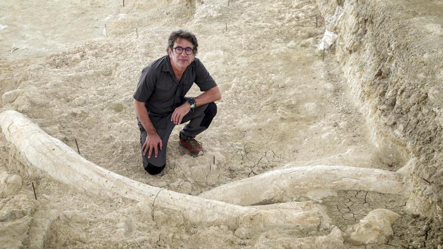 El profesor de arqueología Juan Manuel Jiménez en el yacimiento de Fuente Nueva ante dos colmillos de mamut.
