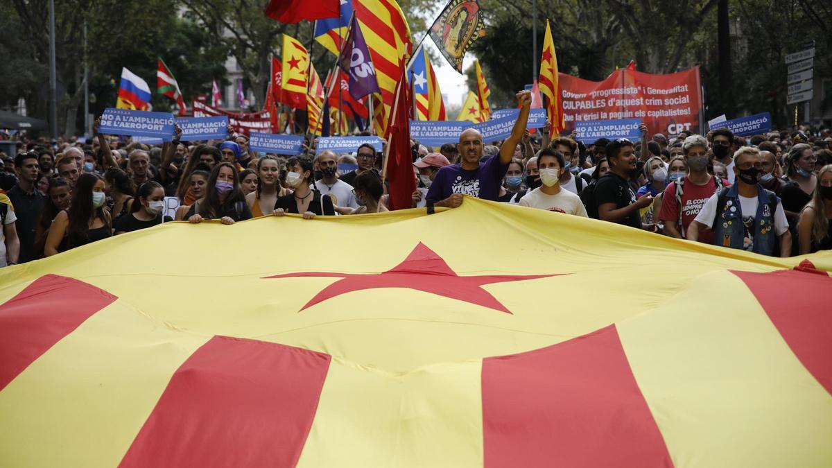 Varias personas sujetan una bandera estelada durante la manifestación organizada por la Izquierda Independentista, con motivo de la Diada, día de Cataluña.