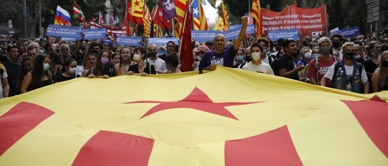 Varias personas sujetan una bandera estelada durante la manifestación organizada por la Izquierda Independentista, con motivo de la Diada, día de Cataluña, a 11 de septiembre de 2021, en Barcelona, Catalunya (España). Esta manifestación ha sido organizada