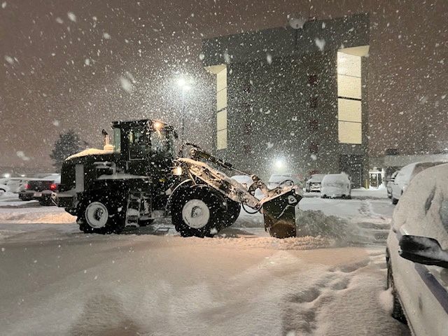 New York National Guard clear out snow from a parking lot in Cheektowaga, New York