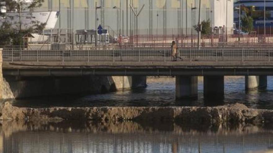 Barrera de arena que se ha formado debajo del puente de la avenida de Elche y que impide el desagÜe y entrada de agua en el barranco.