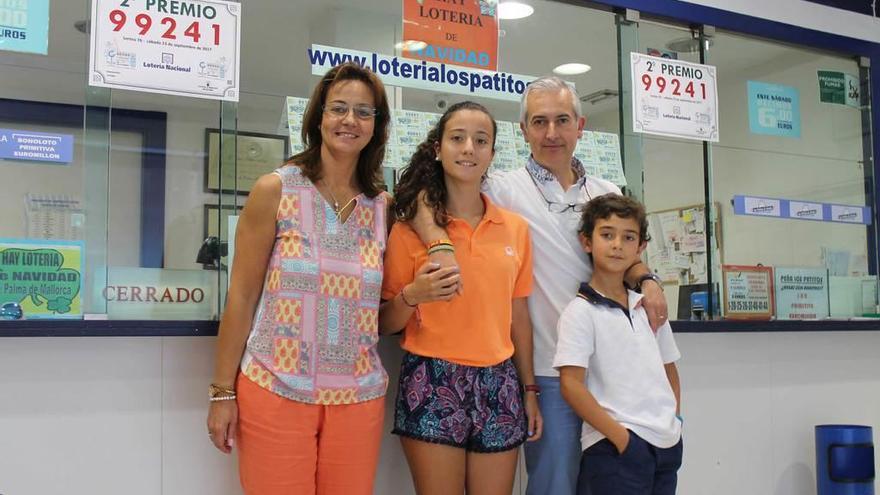 Inés Garzo; su marido, José Carlos Méndez, y sus hijos Carlota y Guillermo, junto al cartel del segundo premio de la lotería nacional.