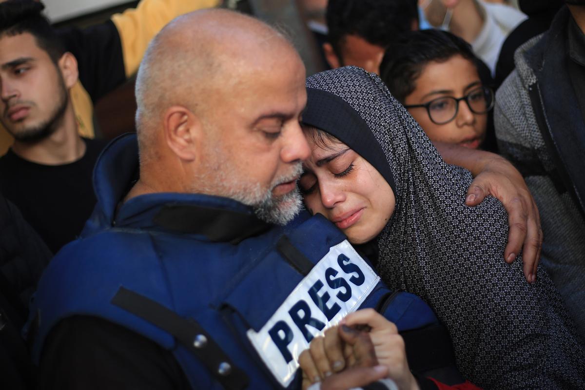 07 January 2024, Palestinian Territories, Rafah: Wael Dahdouh, Al-Jazeera bureau chief in Gaza, comforts a family member as they mourns over the body of his dead son Hamza, who also worked as a journalist for Al Jazeera and was killed in an Israeli air strike on Rafah. Dahdouh has previously lost his wife, two other children and a grandson and was injured himself during the war. Photo: Mohammed Talatene/dpa 07/01/2024 ONLY FOR USE IN SPAIN / Mohammed Talatene/dpa;Politics;---;politics;war;conflict;unrest;Israeli-Palestinian conflict - Journalists funeral in Rafah