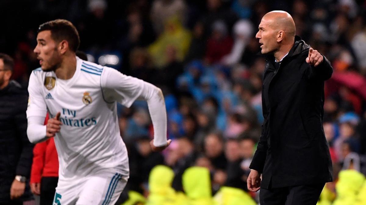 Zinedine Zidane sigue el partido contra el Getafe mientras Theo sube la banda.