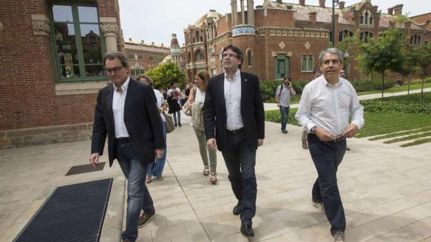 Puigdemont, flanqueado por el expresident Artur Mas (izq.) y el cabeza de lista de CDC, Francesc Homs. // Efe