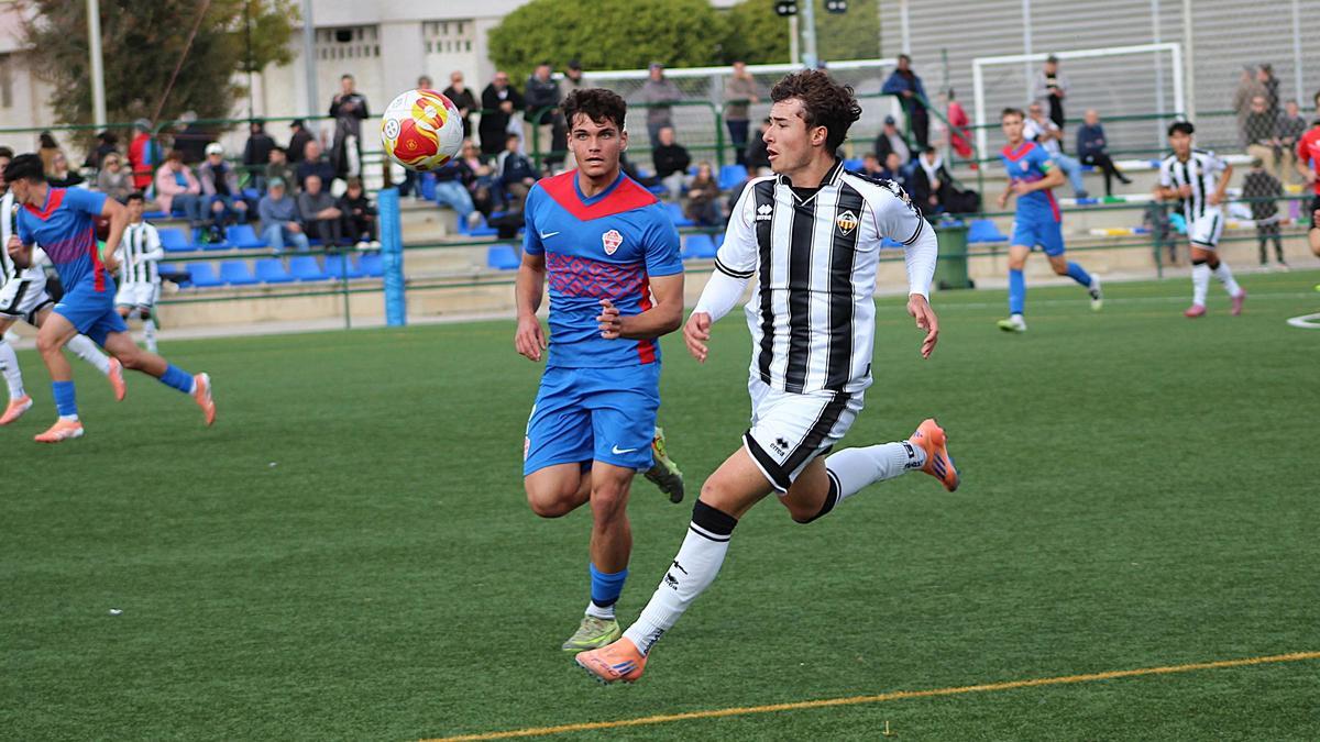 El lateral zurdo José Nadal corre por la banda para controlar un balón ante un rival del Elche.