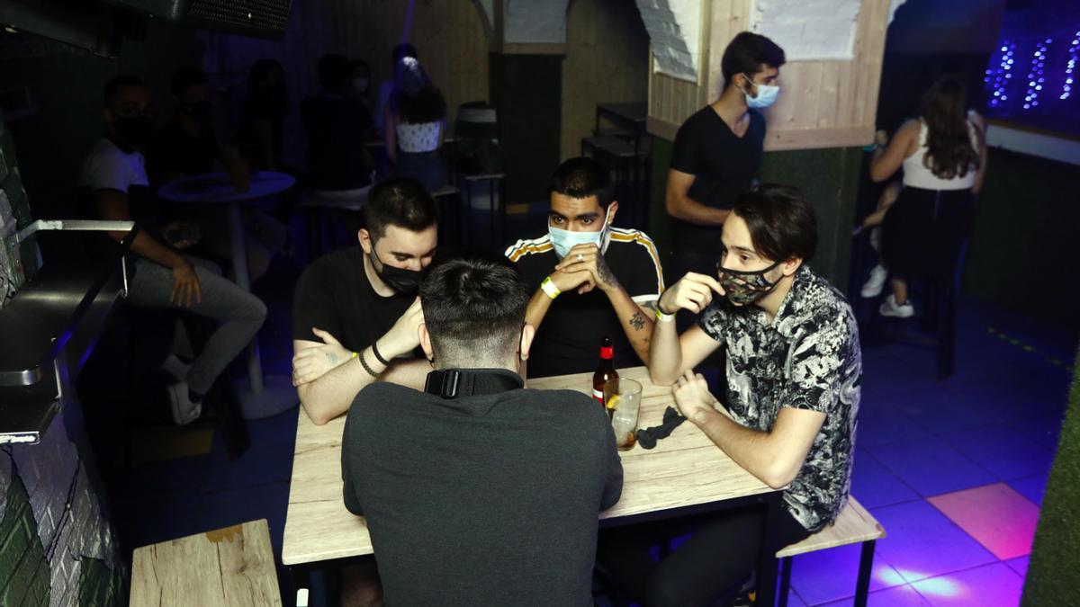 Varios jóvenes disfrutando de una noche de ocio, con sus mascarillas, en el bar Campus.