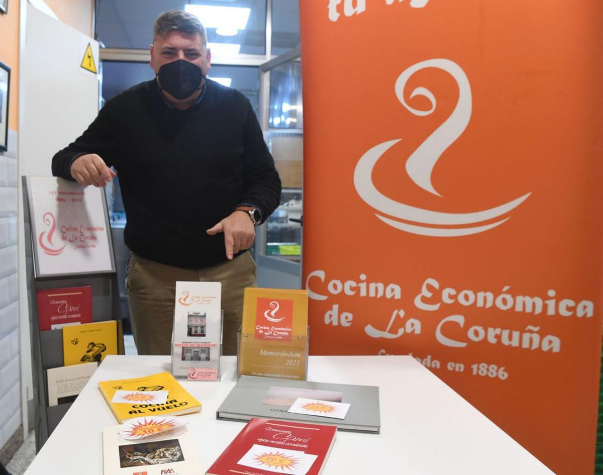 Óscar Castro, ayer, con los libros solidarios de la Cocina Económica.   | // C. PARDELLAS