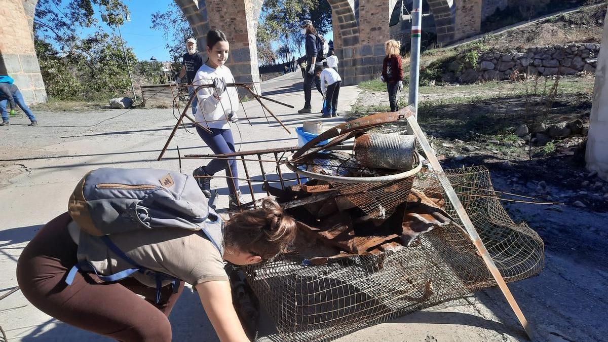 Los vecinos de la zona afectada por el impactante incendio de Bejís se reúnen para recoger residuos reaparecidos después de la quema de la vegetación.