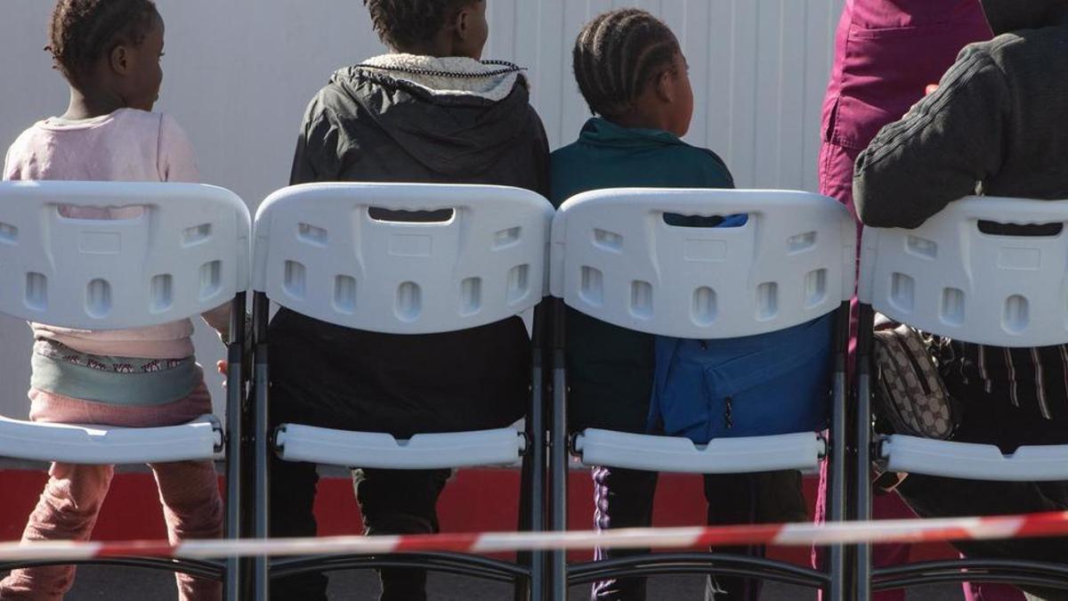 Menores migrantes esperan ser atendidos tras su llegada a Puerto del Rosario.