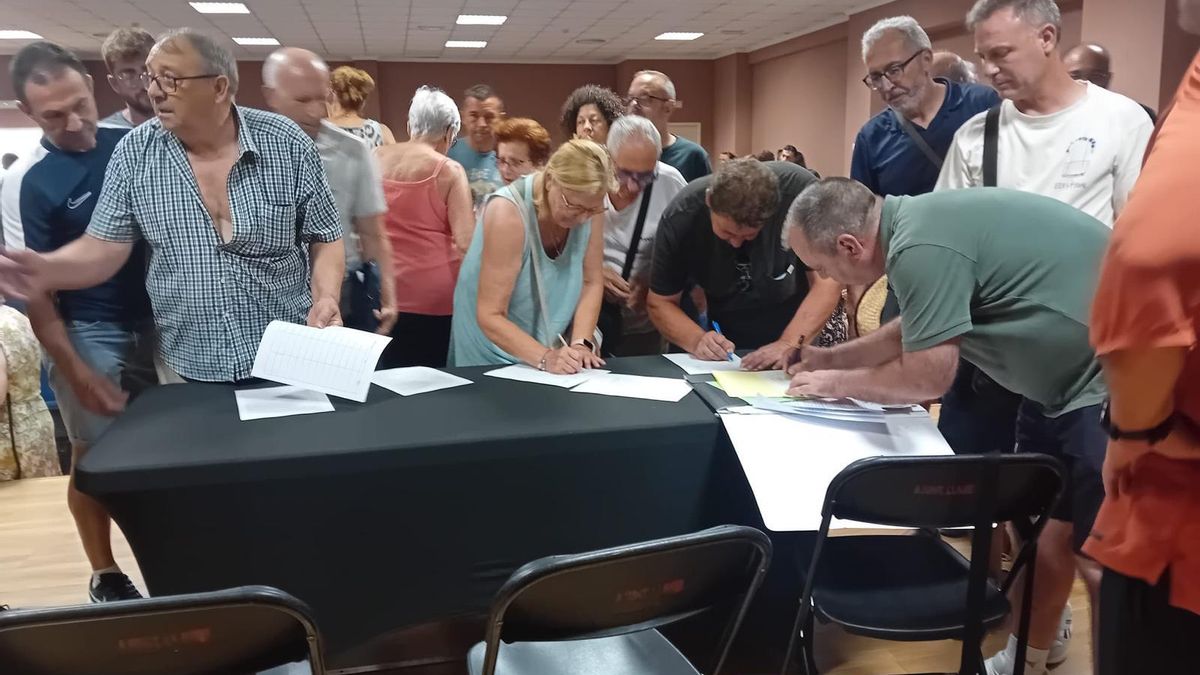 Asistentes a la asamblea informativa firman en contra de la planta fotovoltaica.