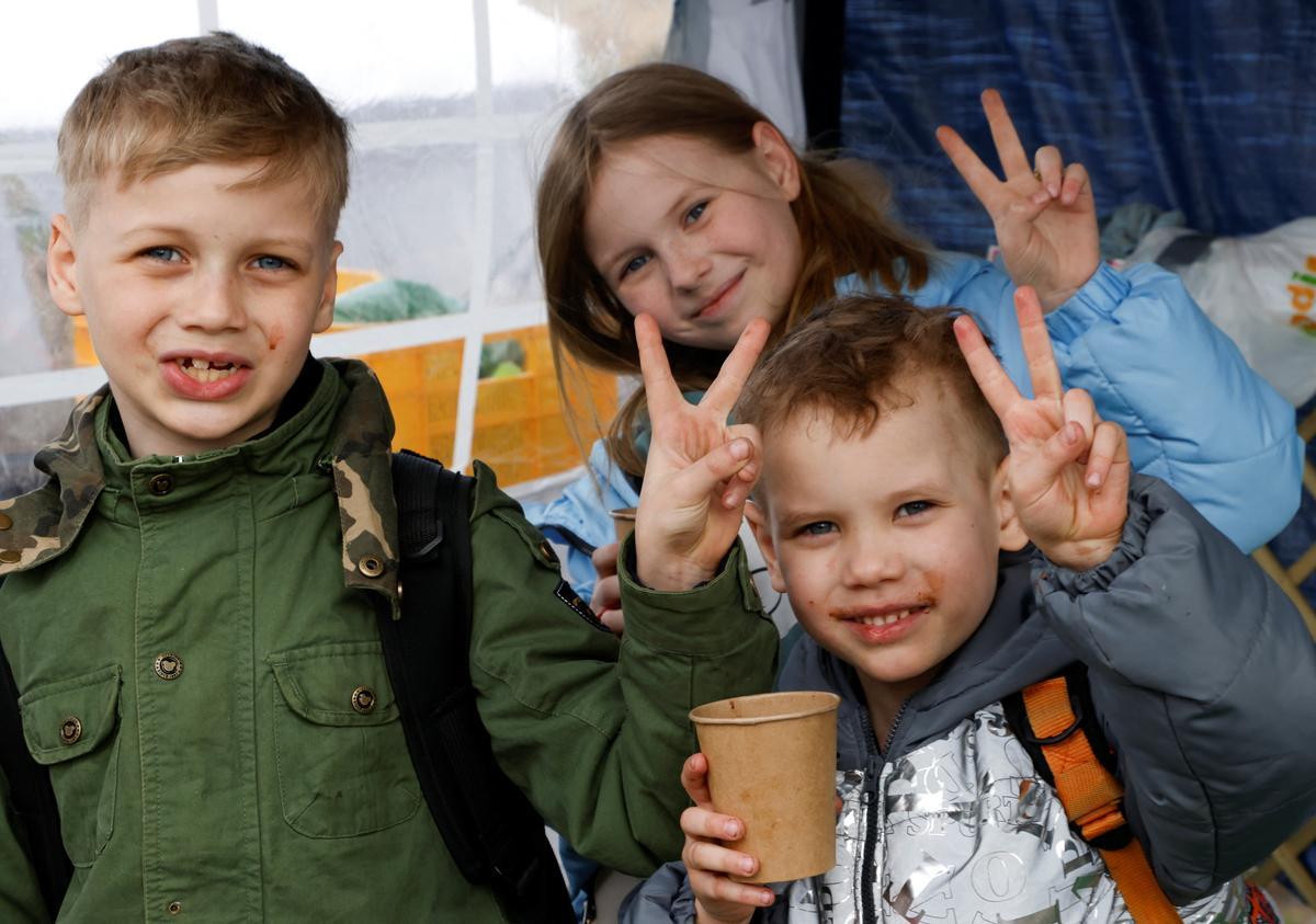 Huyendo de Ucrania en medio de la invasión de Rusia llegan a Medyka. Los refugiados ucranianos Maxim, Sergej y Nastja posan para una fotografía después de un viaje de 30 horas con sus padres desde la región de Donetsk, después de cruzar la frontera entre Ucrania y Polonia, en medio de la invasión rusa de Ucrania, en Medyka, Polonia.