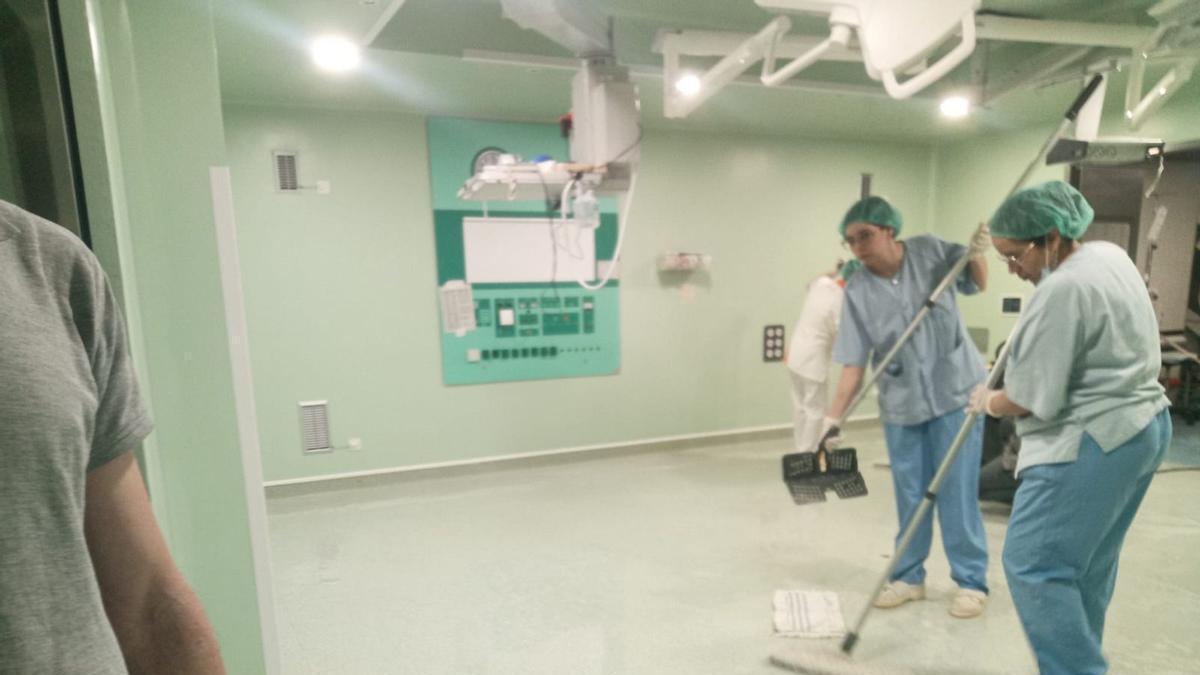 Las trabajadoras limpian la rotura de la tubería en el Clínico