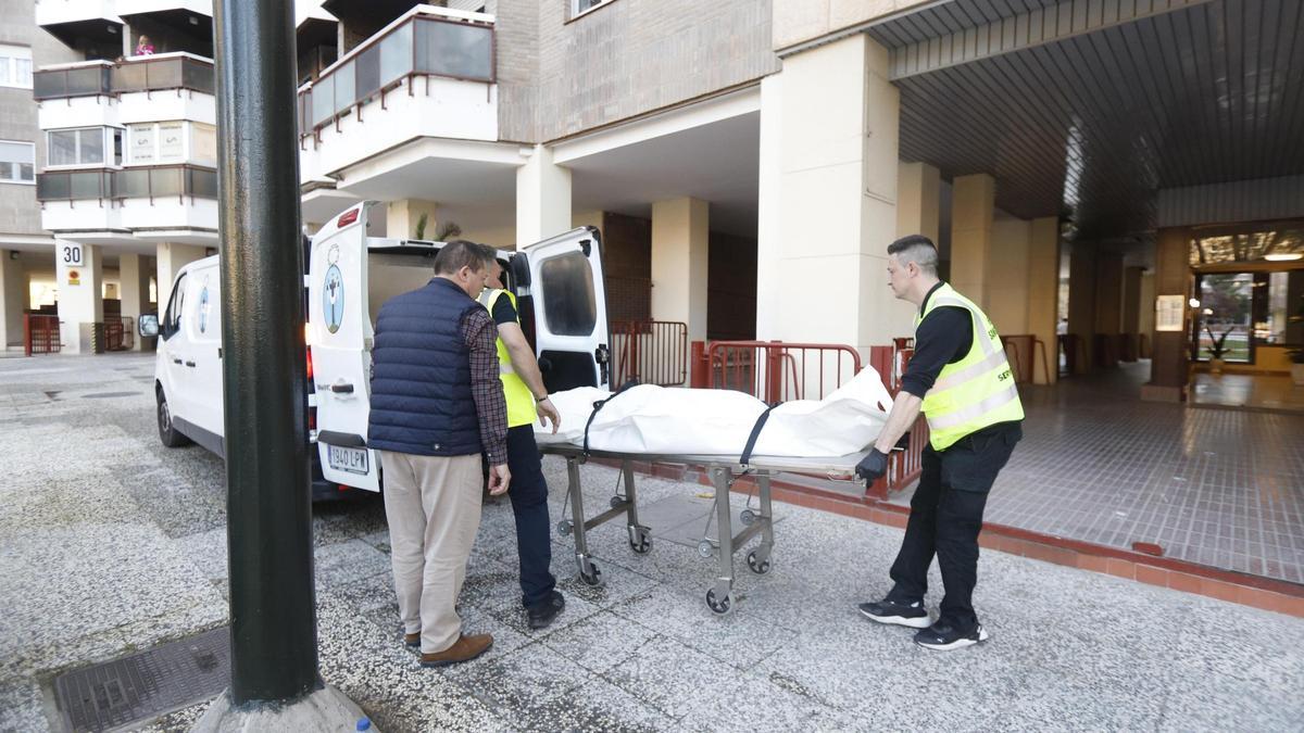 Trabajadores de la Hermandad de la Sangre de Cristo retiran el cadaver de la fallecida.