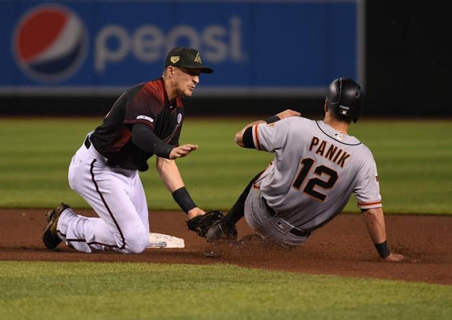 Nick Ahmed # 13 de los Arizona Diamondbacks marca a Joe Panik # 12 de los Gigantes de San Francisco en la segunda base durante la cuarta entrada en el Chase Field en Phoenix, Arizona.