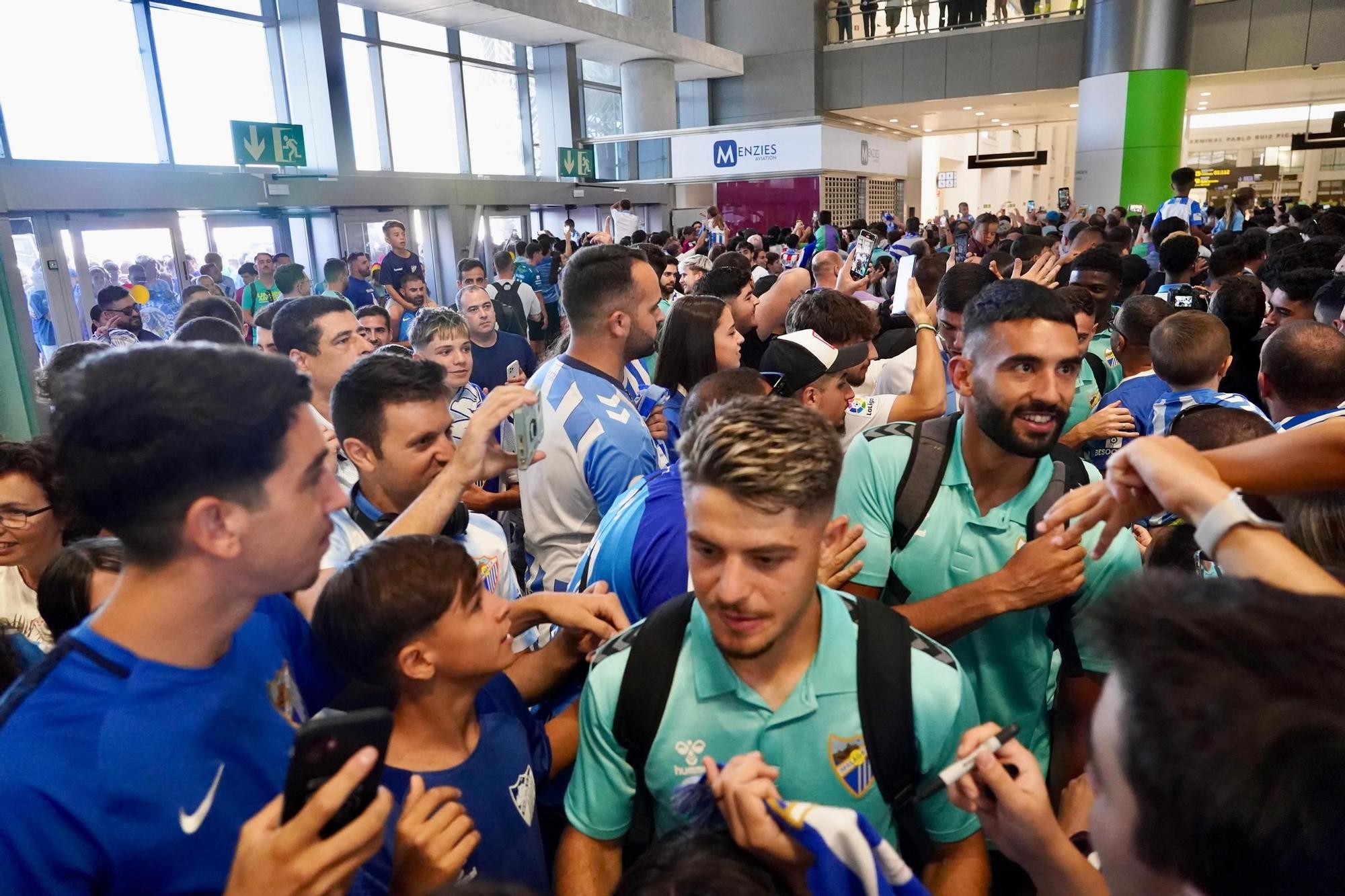 La afición del Málaga CF toma el aeropuerto para despedir al equipo