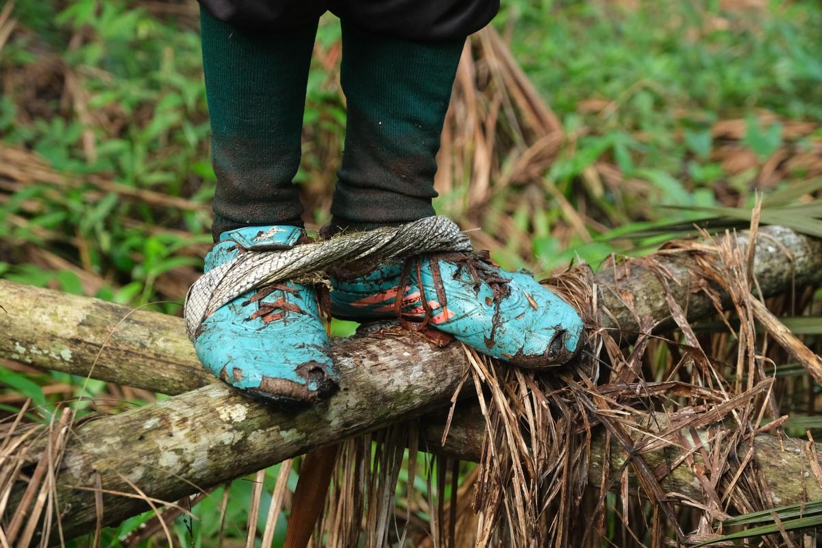 Joao Lira con sus zapitas y su amarre para poder agarrarse bien para trepar la palmera.