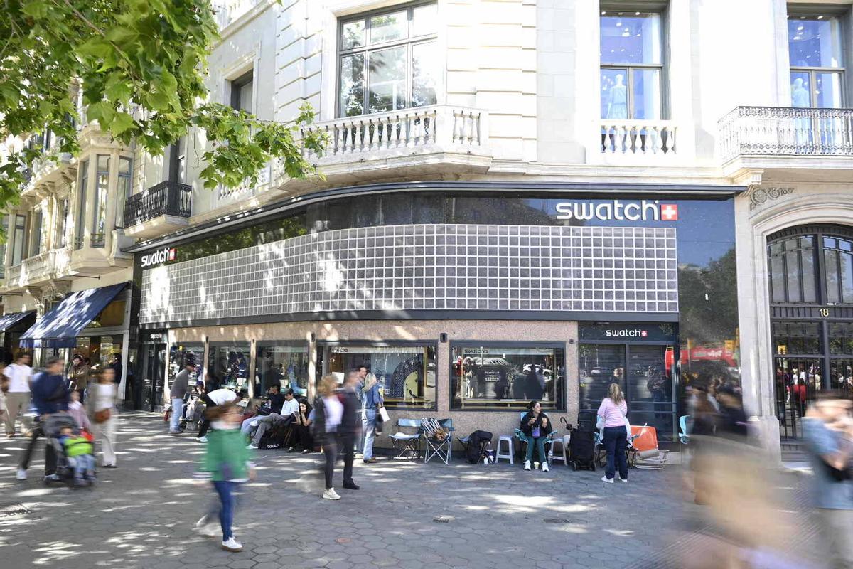 Cola de posibles compradores en el exterior de la tienda Swatch en Paseo de Gracia esquina Gran Vía, cerrada por motivos de seguridad según anuncia un cartel, a raíz de la venta del modelo Swatch creado en colaboración con la firma de relojes de lujo Audemars Piguet