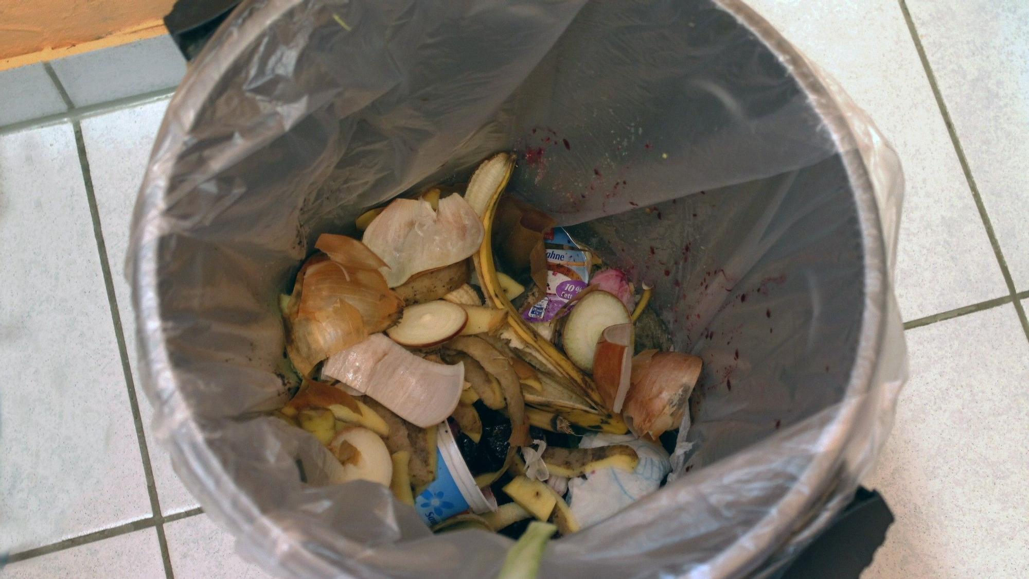 Cubo de basura con restos y desperdicios en una cocina