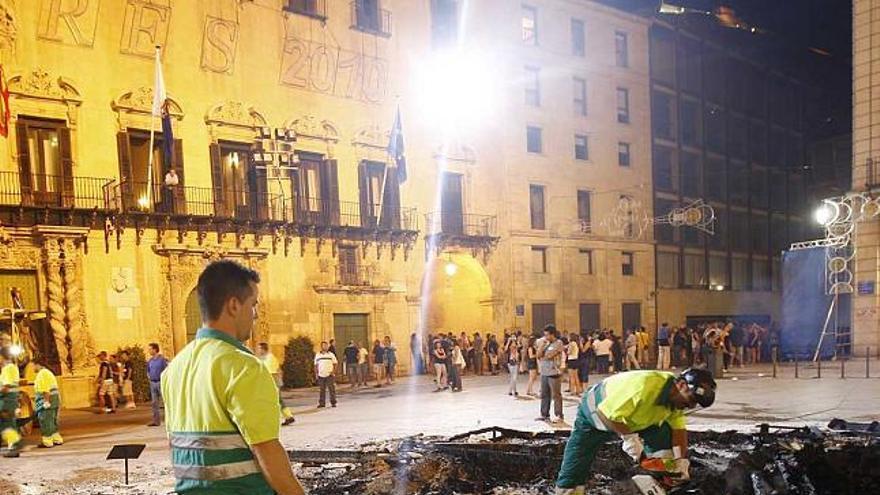 Un grupo de operarios recoge los escombros tras la cremà de la Hoguera Oficial.