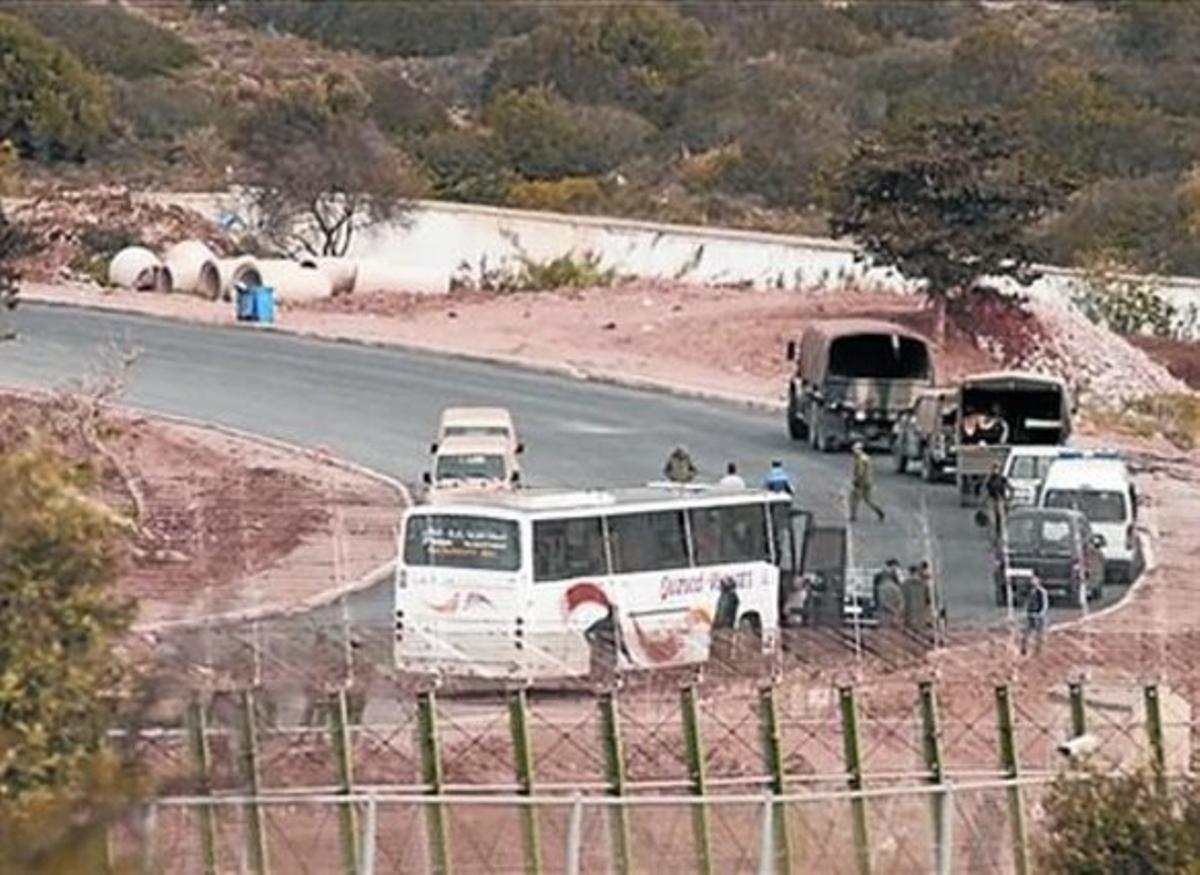 A l’esquerra, els militars marroquins, entre les dues tanques, davant dels immigrants. A la dreta, l’autocar que es va endur de tornada els subsaharians. A l’esquerra, els militars marroquins, entre les dues tanques, davant dels immigrants. A la dreta, l’autocar que es va endur de tornada els subsaharians.