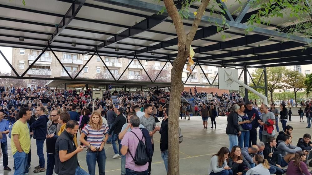 La gent espera l'arribada de la policia a l'escola el Pla.