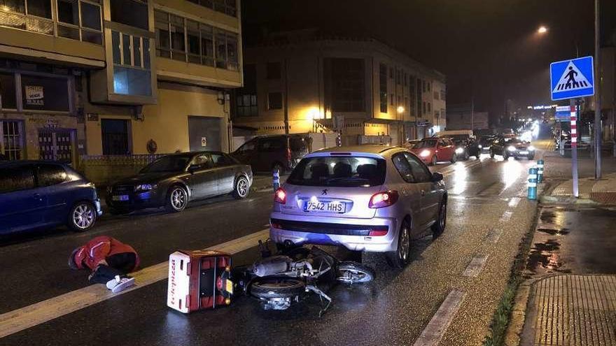 El joven piloto quedó tendido en la calzada tras impactar contra el turismo que le precedía. // G.N.