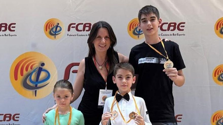Els tres medallistes amb Eva Serra, directora i professora de l'escola.