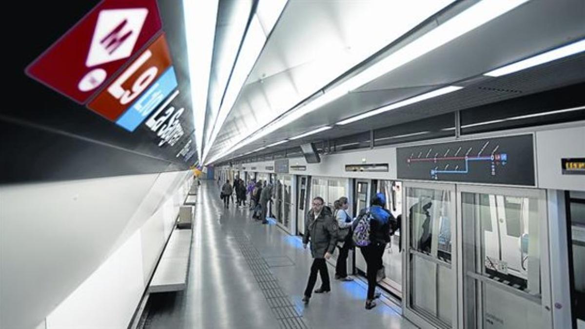 Movimiento de pasajeros a la llegada de un metro de conducción automática a los andenes cerrados de la L-9 en el intercambiador de La Sagrera, ayer.