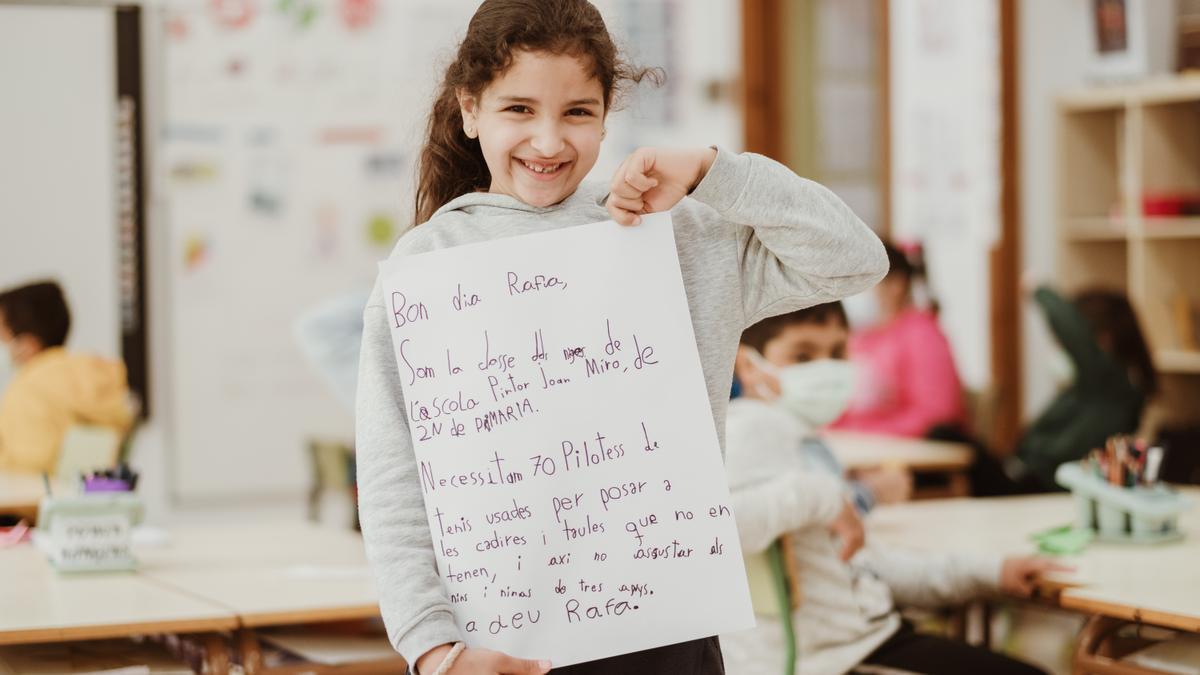 Una niña de 2º de Primera posa con la carta que le han escrito a Rafa Nadal