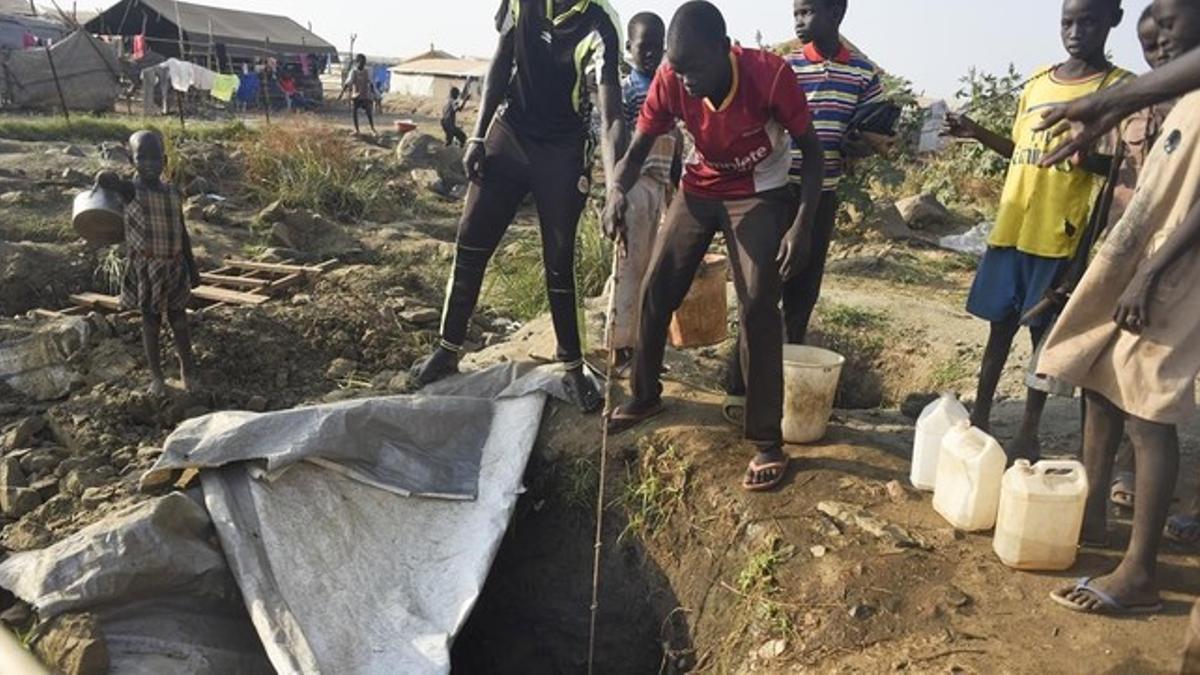 Desplazados por el conflicto civil sacan agua de un pozo en un campo de refugiados de Juba.