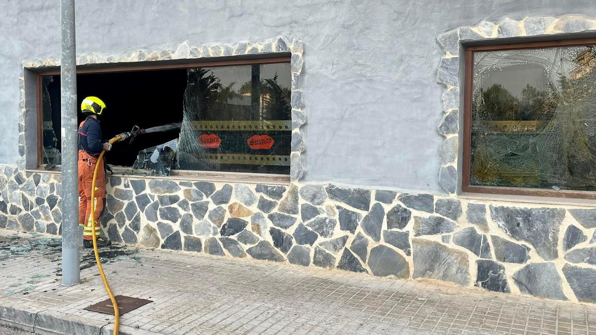 Un bombero sofoca el incendio en el interior de un pub de Silla.