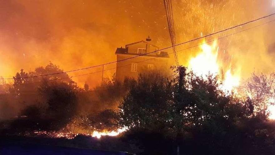 Casa cercada por el fuego en Fragoselo, en Coruxo. // Fdv