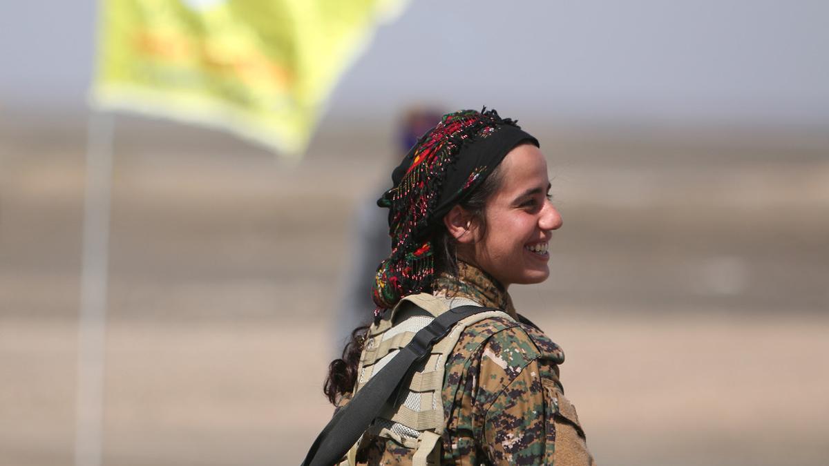 A Syrian Democratic Forces (SDF) female fighter reacts east of Raqqa city