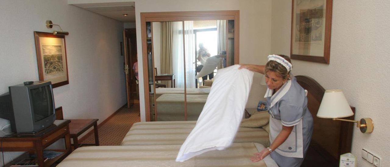 Una trabajadora realiza el cambio de sábanas en la habitación en un hotel.