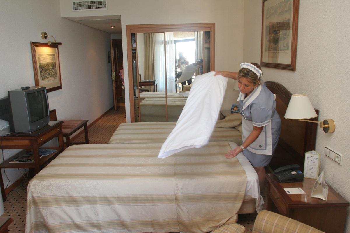 Una trabajadora realiza el cambio de sábanas en la habitación en un hotel.