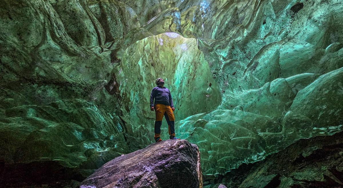 Der Reisefotograf in einem grünen Gletscher in Kulusuk, Ostgrönland.