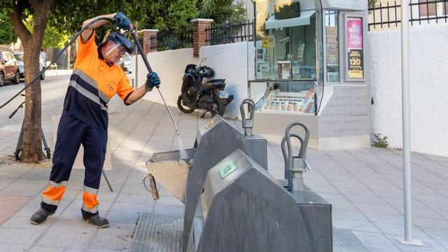 Un operario limpia un contenedor soterrado en uno de los barrios de Marbella.