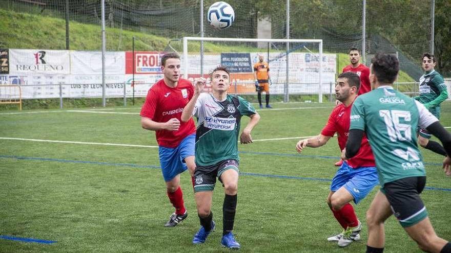 La pelota por el aire y futbolistas de Valenzá y Verín que pelean por hacerse con ella. // C.P.