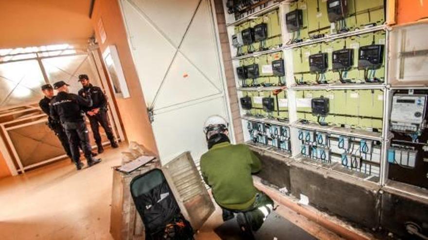 Técnicos de Iberdrola y agentes de la Policía Nacional ayer en Elda, durante los trabajos de desconexión de los enganches ilegales.